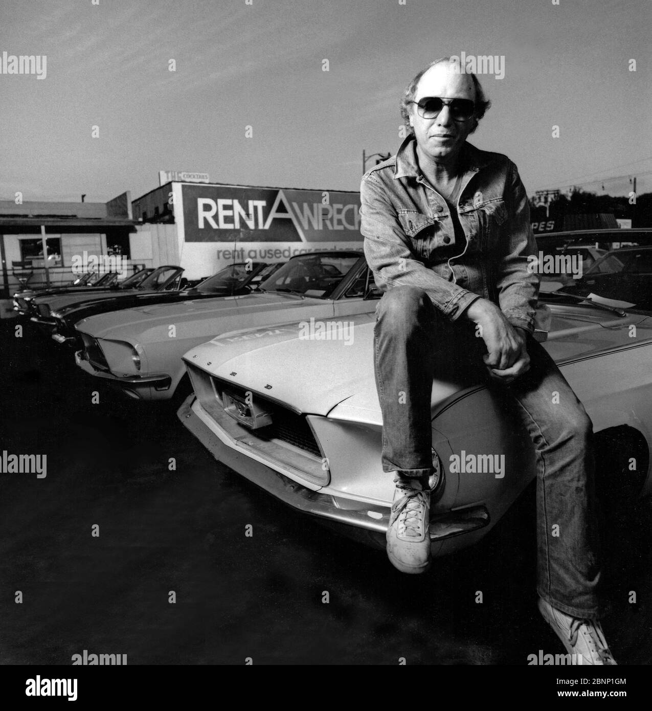 Posierte und beleuchtete Schwarz-Weiß-Porträt von Dave Schwartz, dem Gründer und ursprünglichen Eigentümer von Rent A Wreck Autovermietung in West Los Angeles, CA Stockfoto