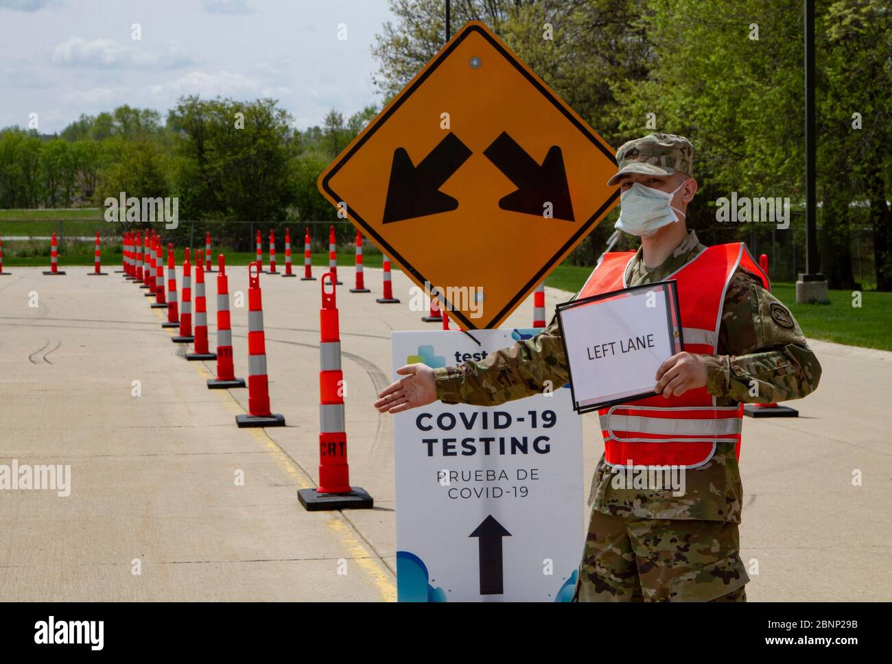 Iowa National Guard Spc. Ben Falkers leitet den Verkehr an einem COVID-19, Coronavirus Drive-Thru-Teststandort am Kirkwood Community College, 7. Mai 2020 in Cedar Rapids, Iowa. Stockfoto