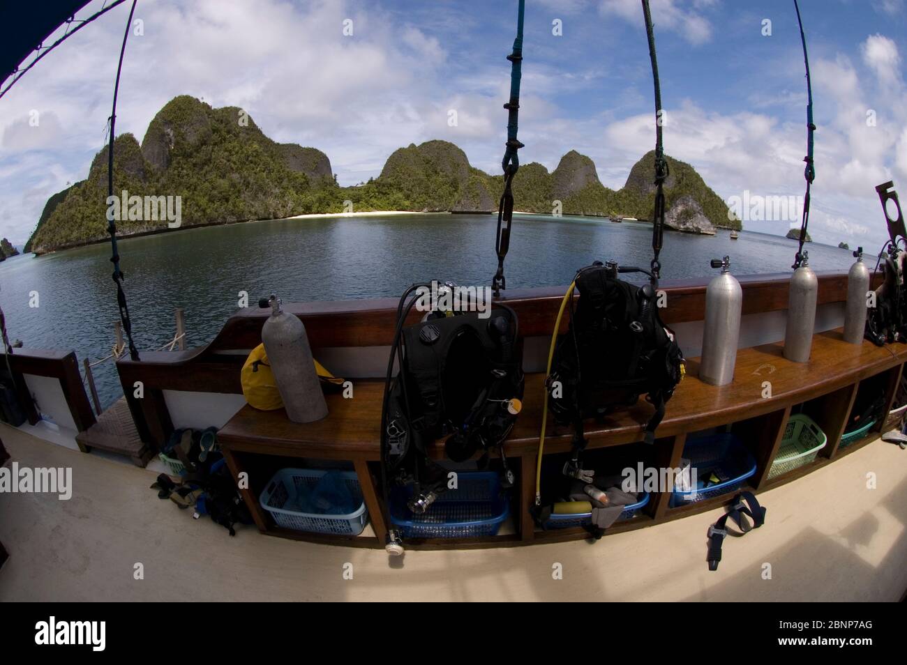 Tauchausrüstung auf dem Boot in der Bucht mit Kalksteinfelsen und Strand, Waigeo Island, Raja Ampat, West Papua, Indonesien Stockfoto