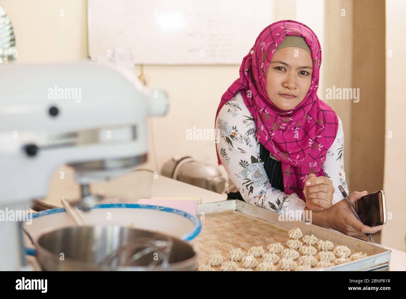 asiatische muslimische Bäcker Blick auf Kamera. Kleinbetrieb Besitzer Stockfoto