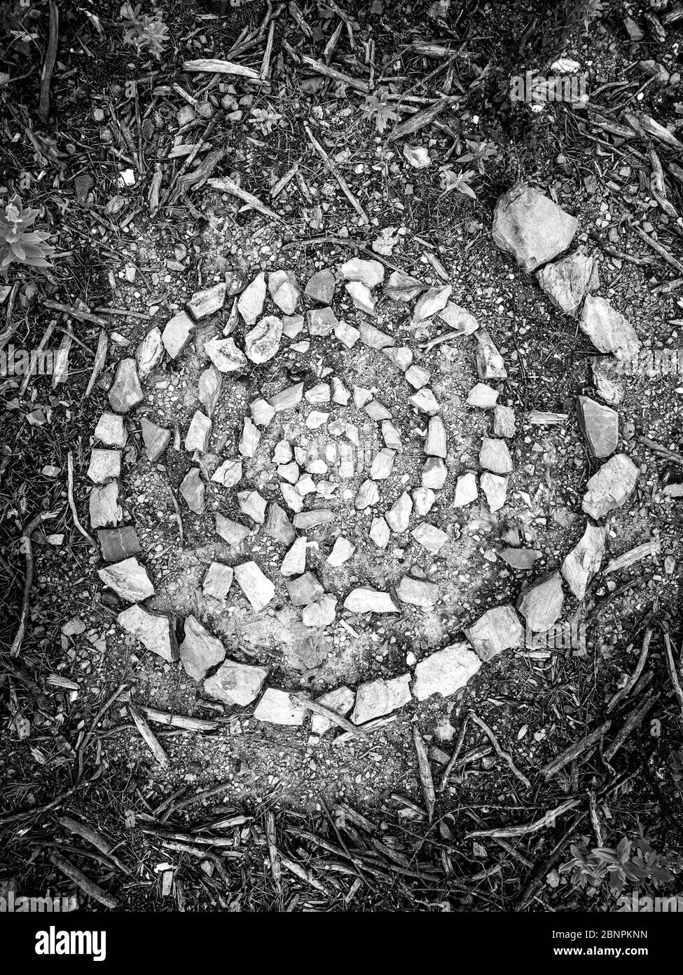 Spirale, die von kleinen Steinen in einem mediterranen Wald gebildet wird Stockfoto