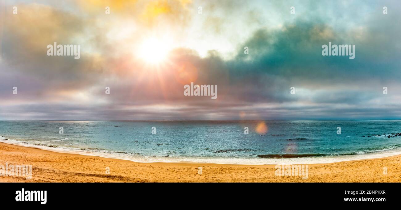 Sonnenstrahlen über einem Sandstrand Stockfoto