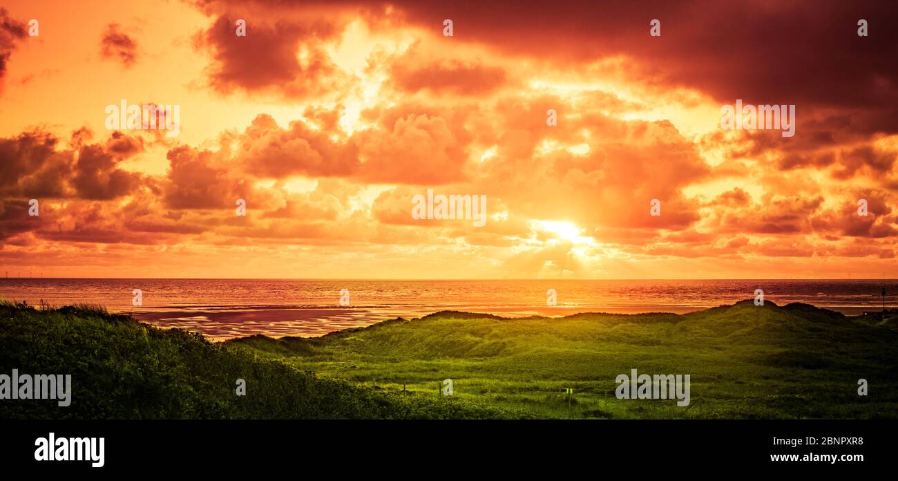 Sonnenuntergang über dem Meer in einer Dünenlandschaft Stockfoto