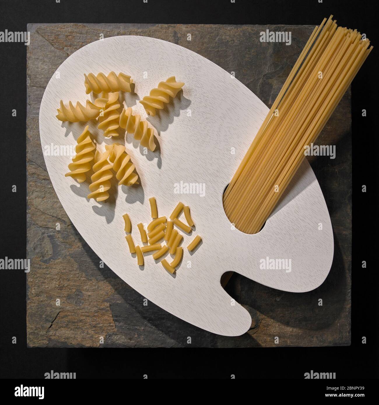 Weiße Palette mit getrockneter Pasta-Auswahl auf Schiefergrund, Studioaufnahme Stockfoto