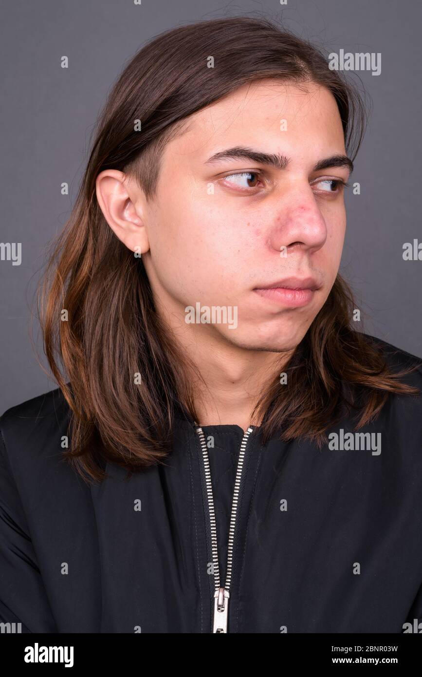 Junger schöner androgyner Mann mit langen Haaren Stockfoto