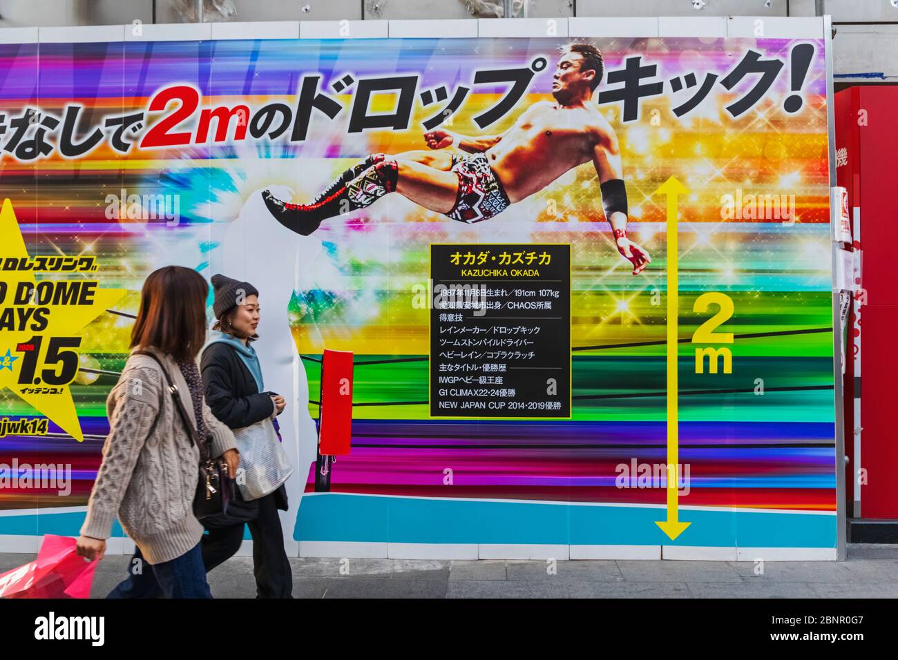 Japan, Honshu, Tokio, Roppongi, Zwei Frauen, Die An Pro-Wrestling-Werbeplakat Vorbeigehen Stockfoto
