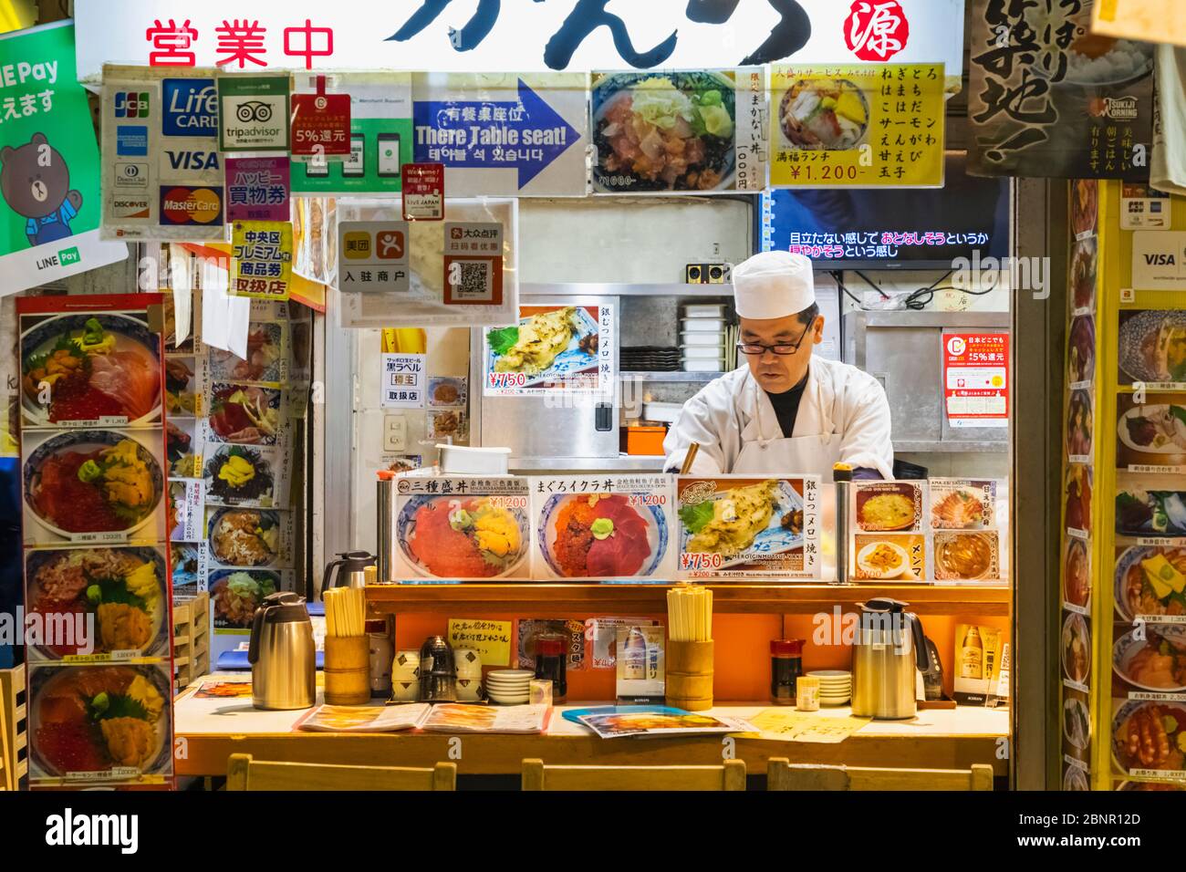 Japan, Honshu, Tokio, Tsukiji, Tsukiji Outer Market, Fischrestaurant mit Küchenchef an Der Theke Stockfoto