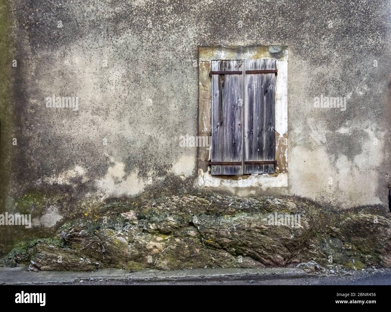 Ates Fenster mit Holzfenster auf Felswand gebaut. Capendu ist eines der runden Dörfer in der Region. Stockfoto