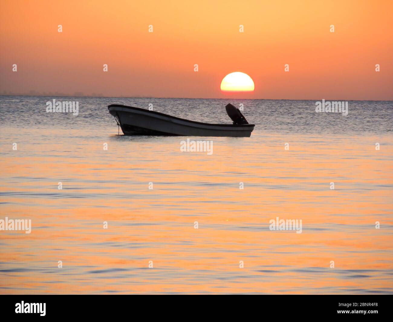 Silhouette eines Motorbootes in der ruhigen geschützten Wasser Maputo Bay, KaNyaka Island, Mosambik, bei Sonnenuntergang Stockfoto