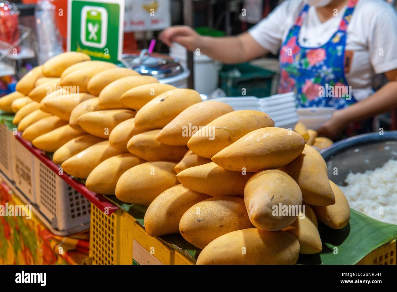 Eine Thailänderin bereitet Mango Sticky Rice auf einem Markt in Nordthailand zu Stockfoto
