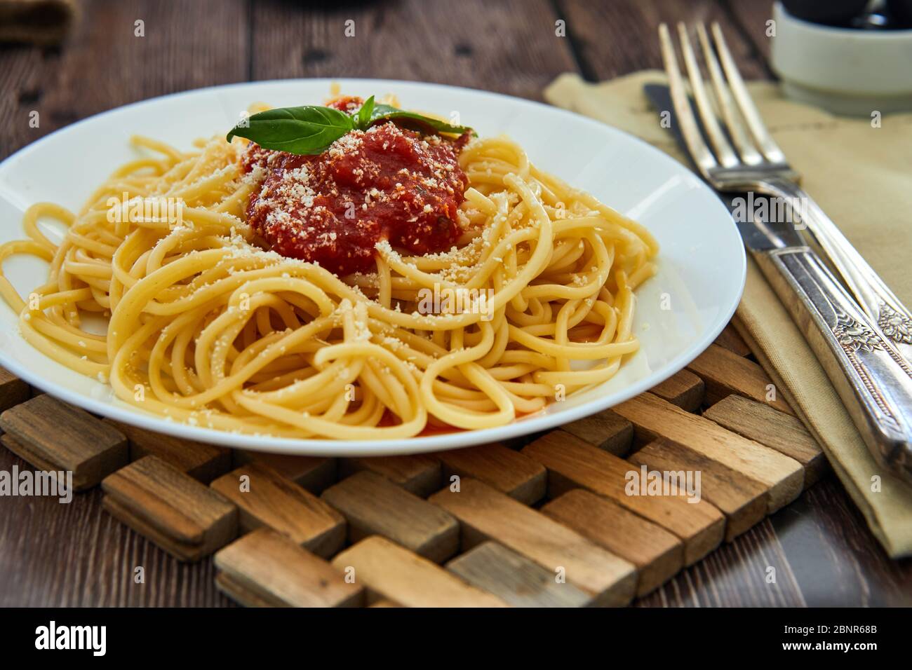 Leckere bunte appetitlich gekochte Spaghetti italienische Pasta mit Tomatensauce Bolognese und frischem Basilikum. Stockfoto