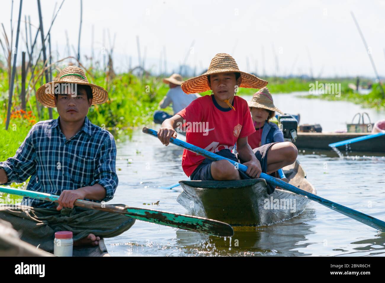 Inle Lake Myanmar - 2. November 2013; Inle Lake Einheimischen paddeln traditionelle Boote entlang Kanal zwischen wachsenden Gemüse in großen Gärten, die schwimmen Stockfoto