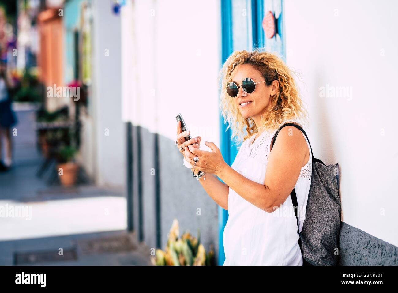 Fröhlich schöne junge kaukasische Frau Porträt im Freien Freizeitaktivitäten - Reisen Menschen und Tourismus Tourist mit Rucksack und Sonnenbrille genießen die Straße zu Fuß Stockfoto