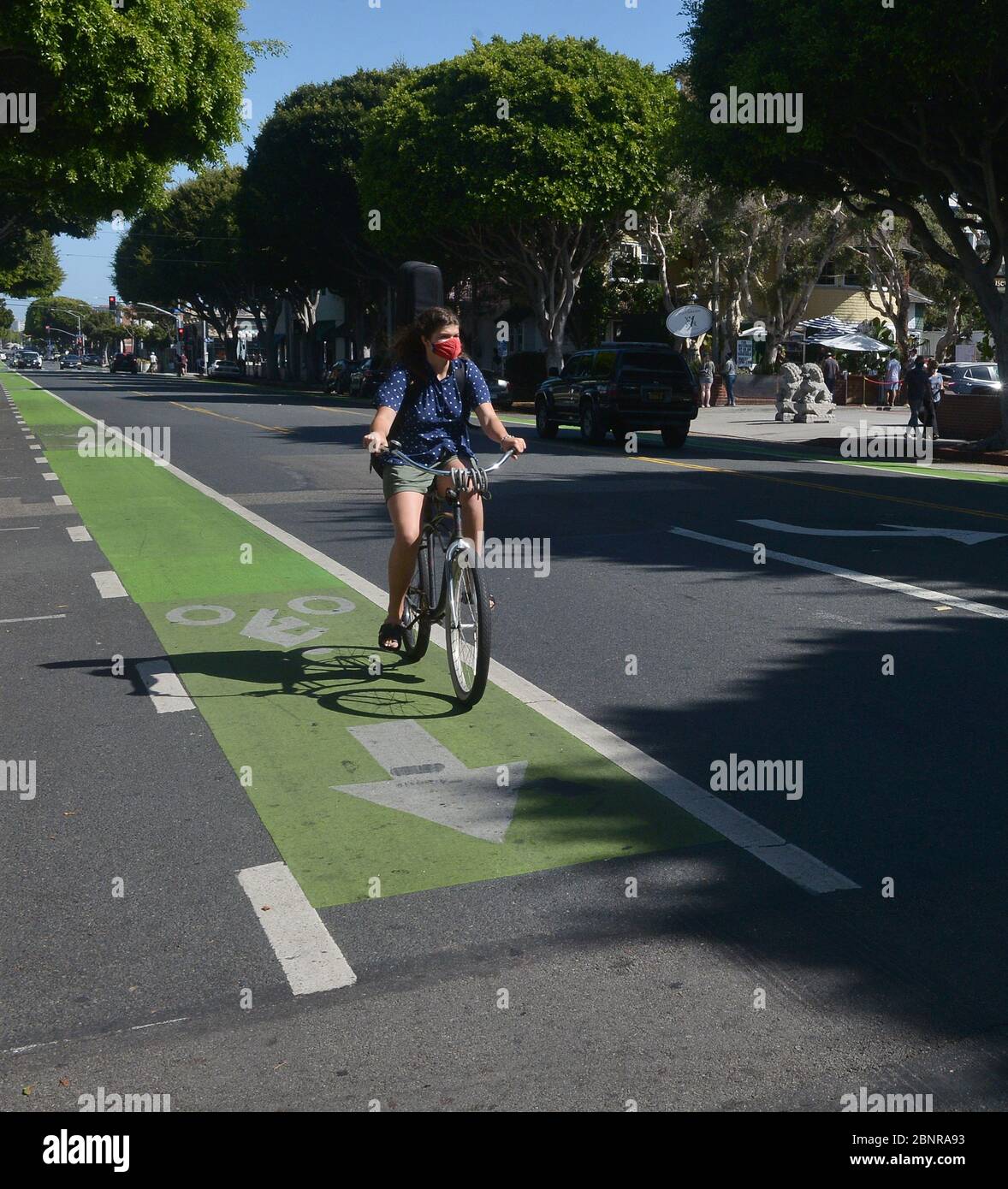 Los Angeles, Usa. Mai 2020. Eine Frau fährt am Freitag, den 15. Mai 2020, die Main Street in Santa Monica, Kalifornien, mit dem Fahrrad hinunter. Beamte der Stadt und des Landkreises sagten, dass die Bewohner Gesichtsbedeckungen tragen müssen, wenn sie ins Freie gehen. Freizeiteinrichtungen wie Reitzentren, Tennis- und Pickleball-Plätze und Gemeinschaftsgärten, die am Freitag wiedereröffnet wurden, mit Einschränkungen wie Gesichtsbedeckungen, sozialer Distanz und Einschränkungen für Besucher. Foto von Jim Ruymen/UPI Quelle: UPI/Alamy Live News Stockfoto