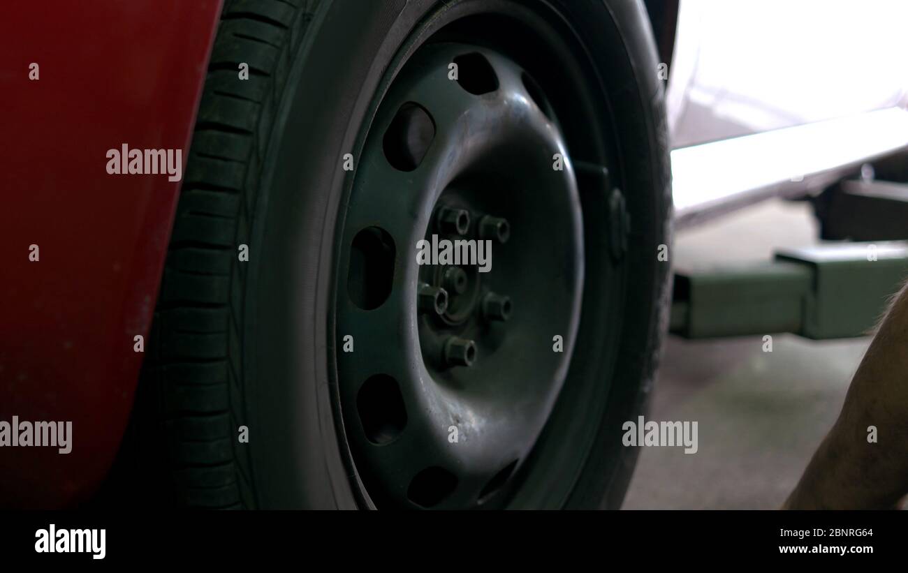 Anziehen der Muttern im Autorad. Stockfoto