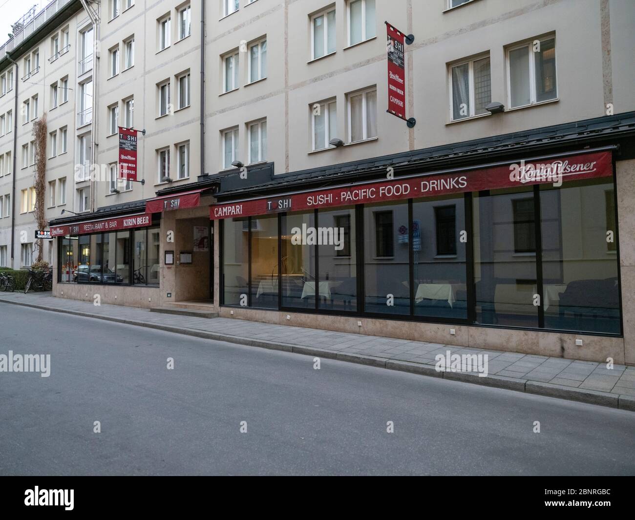 Geschlossenes Restaurant wegen Corona-Virus mit einer autofreien und menschenleeren Straße in der Innenstadt von München Stockfoto