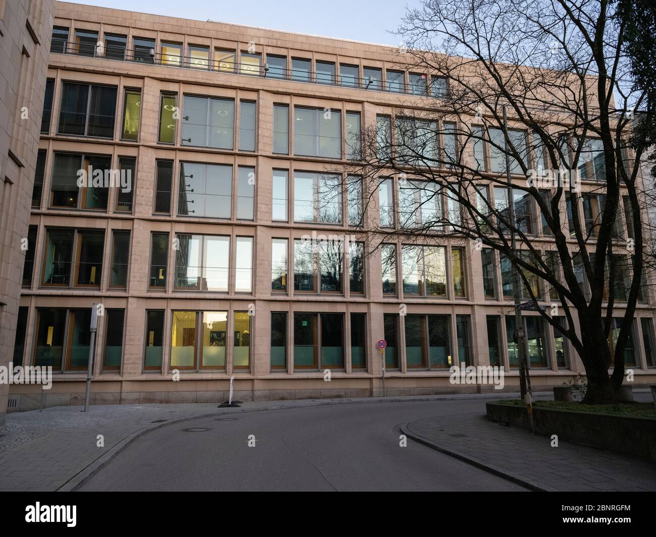 Bürogebäude mit wenig beleuchteten Büros in der leeren Innenstadt von München während der Corona Virus Periode Stockfoto