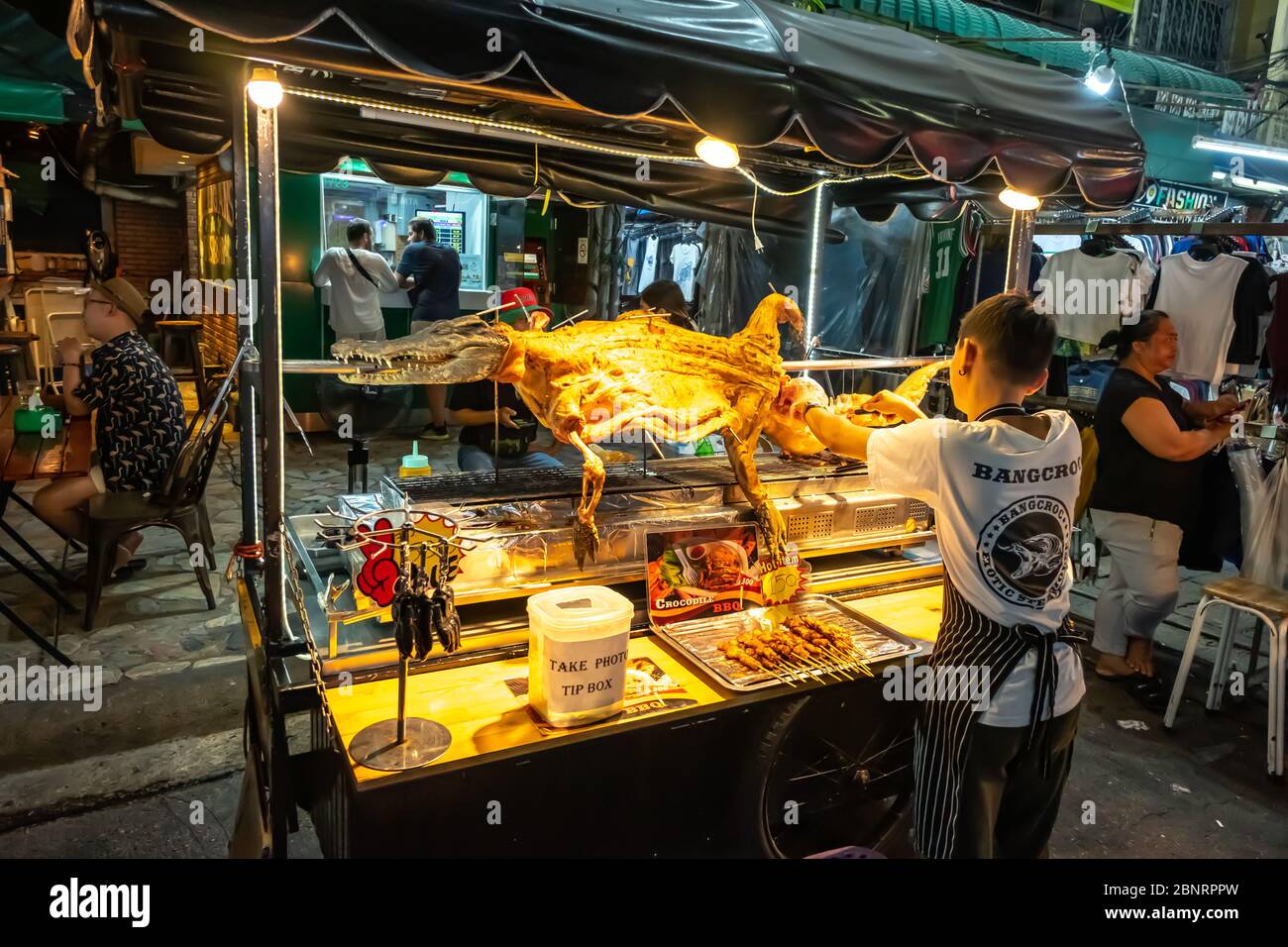 Khao San Road, Bangkok / Thailand - 8. Februar 2020: Bangkok Street Verkäufer verkauft Krokodilfleisch in der Nacht Stockfoto