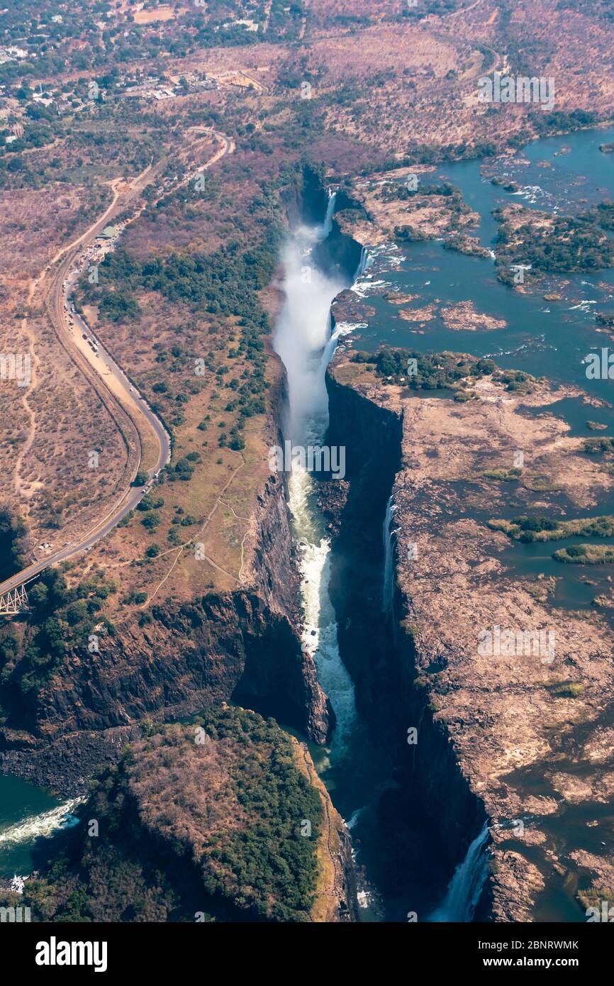 Spektakuläre Luft von Victoria Falls Wasserfall und Brücke über den Zambezi, Simbabwe, Afrika in Portrait Orientation Stockfoto