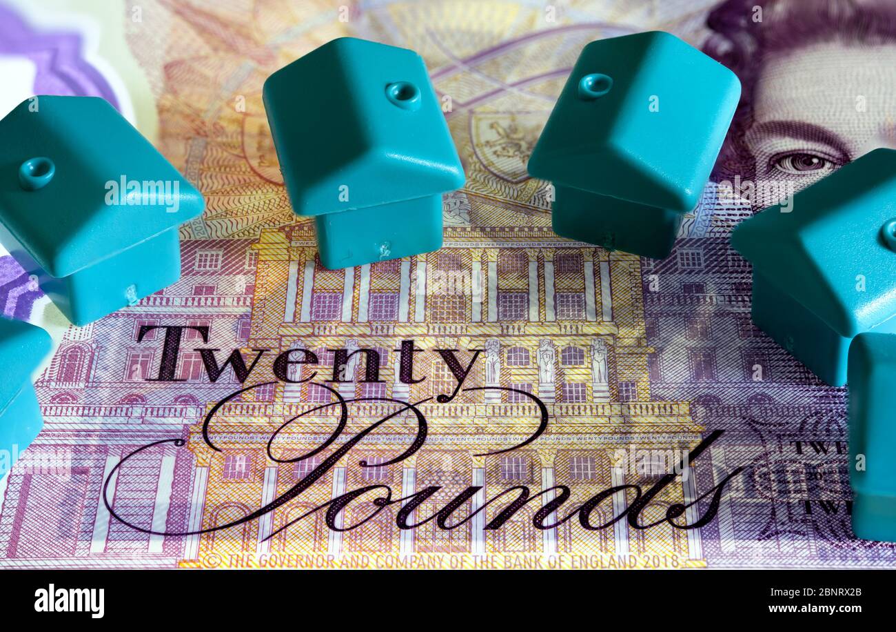Zwanzig Pfund Note mit kleinen blauen Häusern, Investitionskonzept Stockfoto