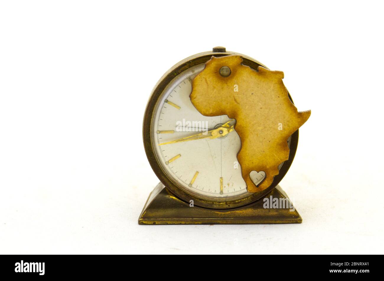 Die Form des afrikanischen Kontinents und eine alte Uhr isoliert auf einem klaren Hintergrundbild mit Kopierraum Stockfoto