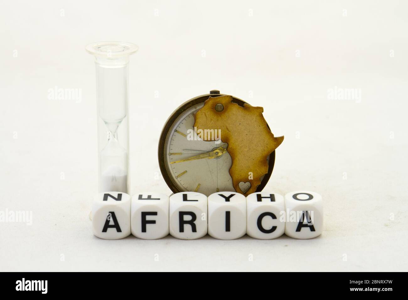 Die Form Afrikas, eine Uhr, eine Sanduhr und der Text Afrika isoliert auf einem klaren Hintergrundbild mit Kopierraum Stockfoto