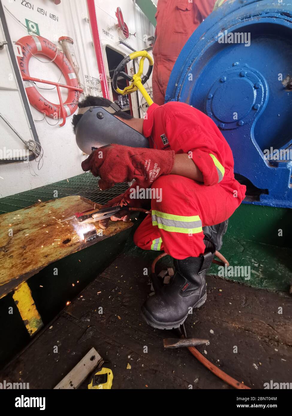 Schweißer fertigt Metallplatte auf Deck Stockfoto