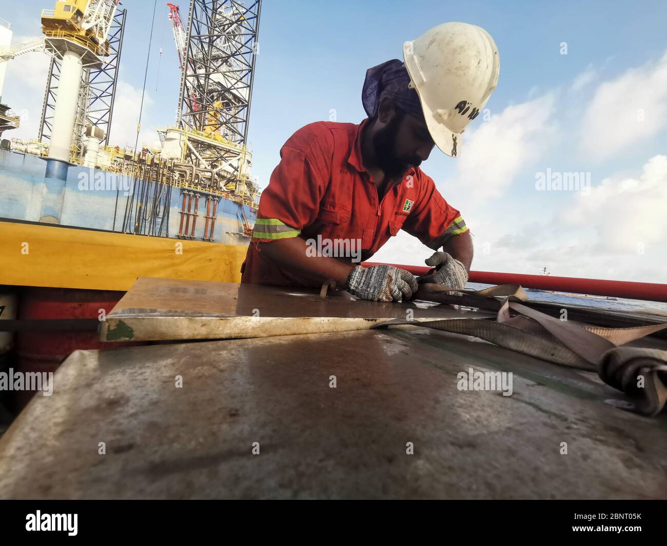 Marine Crew, die Wartungsarbeiten mit vollständiger PSA durchführt Stockfoto