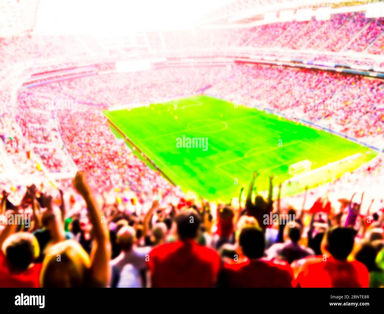 Fußball-Fußball-Fans ihre Mannschaft anfeuern und feiern Ziel in vollen Stadion open Air mit heller Beleuchtung Strahl-unscharf. Stockfoto