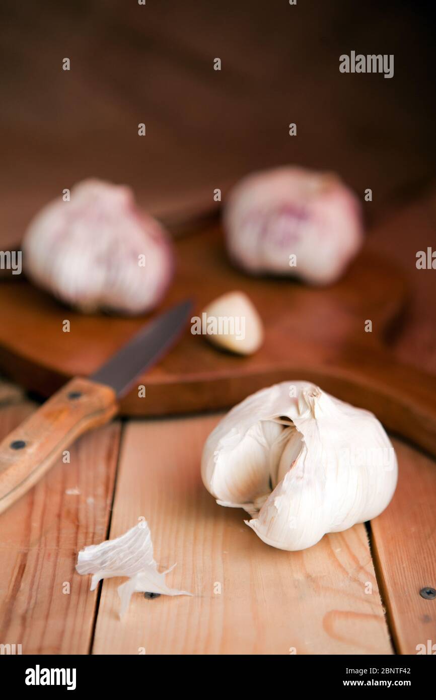 Knoblauchzehen und Knoblauch Zwiebel auf einem weißen Tisch Stockfoto