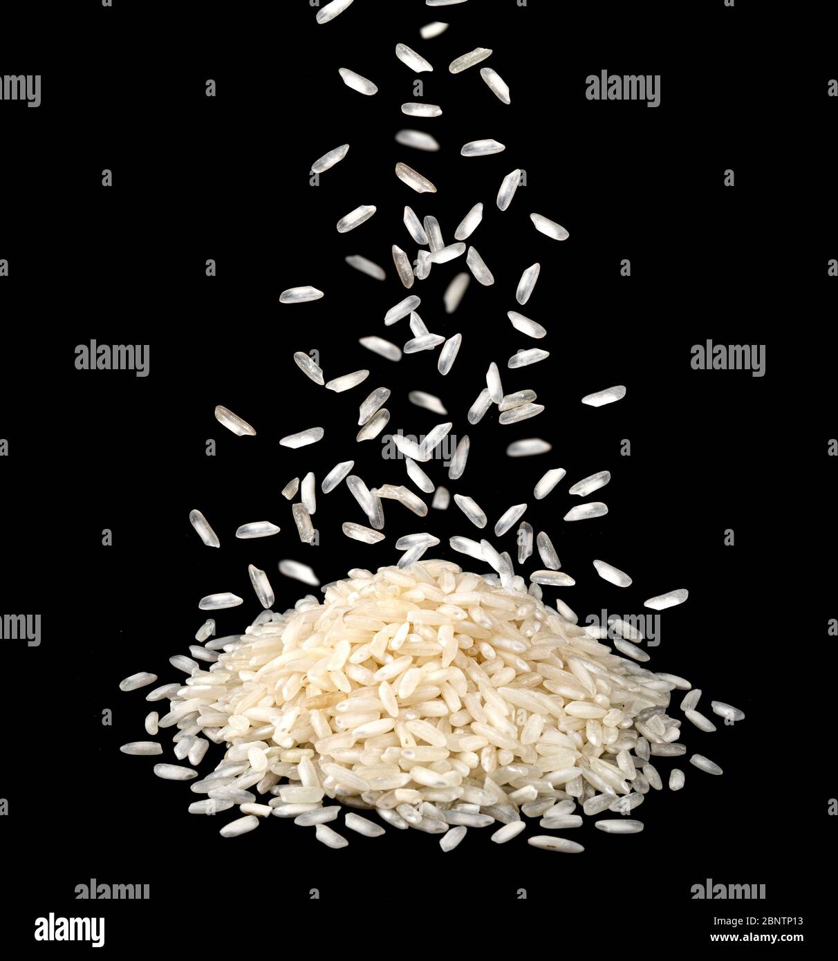 Fallende trockene Reiskörner isoliert auf schwarzem Hintergrund Stockfoto