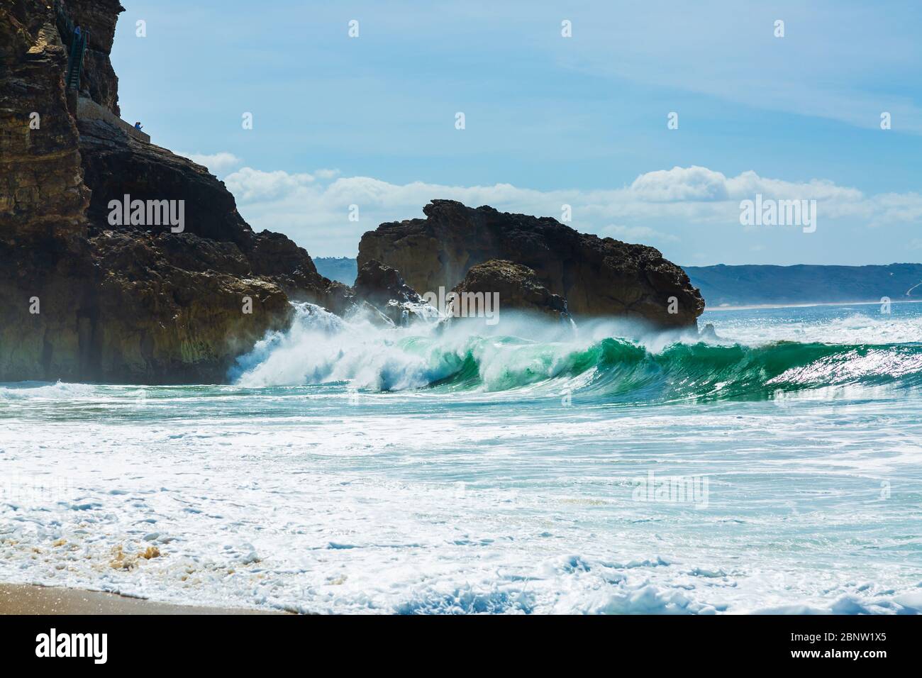 Große Wellen stürzen in die Felsen des North Beach in Nazare City, Portugal Stockfoto