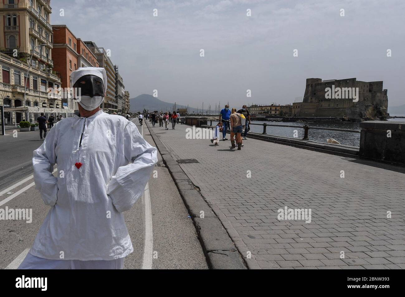 Ein neapolitanischer Künstler, gekleidet als Punch (Pulcinella), Maske der neapolitanischen Theatertradition, tritt unter den Menschen an der Küste von Neapel auf. Italien beginnt mit dem Ende einer nationalen Blockade aufgrund der Ausbreitung der Coronavirus-Krankheit. Stockfoto