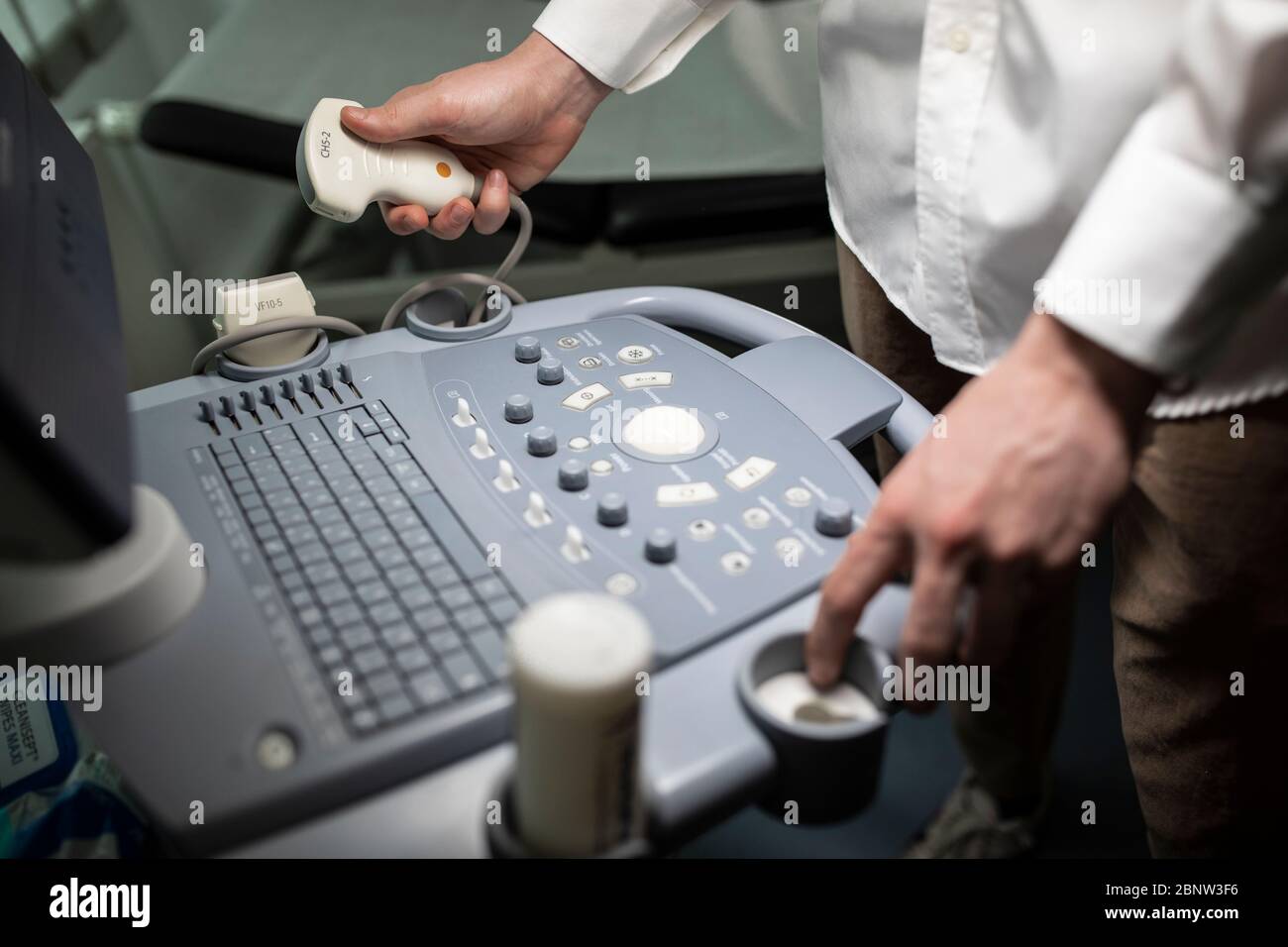 Nahaufnahme eines Technikers, der ein Ultraschallgerät in einer Klinik betreibt. Stockfoto