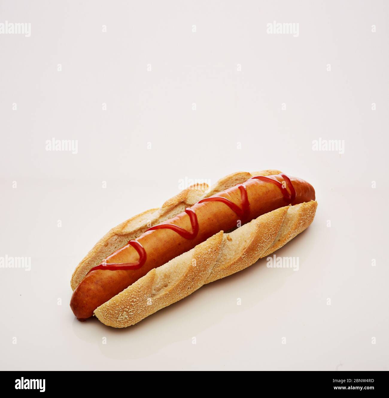 Aufnahme eines Hot Dogs mit großer Wurst und Ketchup isoliert auf weißem Hintergrund Stockfoto