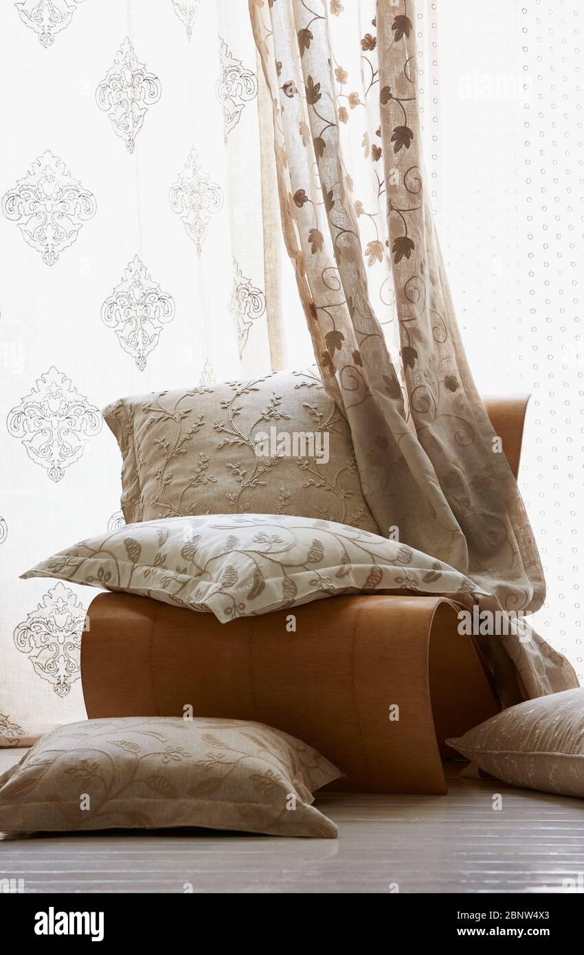 Interieur eines Wohnzimmers mit Kissen, Vorhang und Relaxsessel Stockfoto