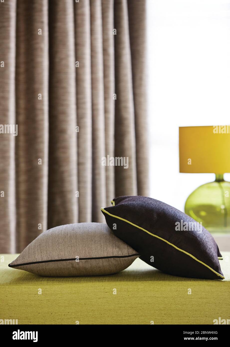 Aufnahme eines gelben Sofas im Wohnzimmer mit bunten Kissen Stockfoto