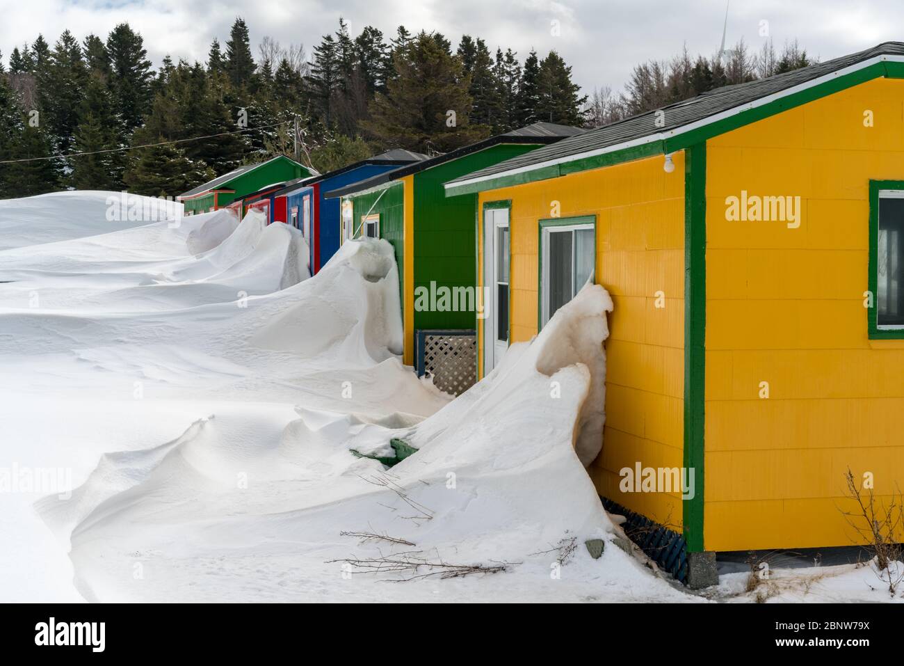 Im ländlichen Quebec, Kanada, bilden sich tiefe Schneeverwehungen gegen bunte Schuppen. Stockfoto