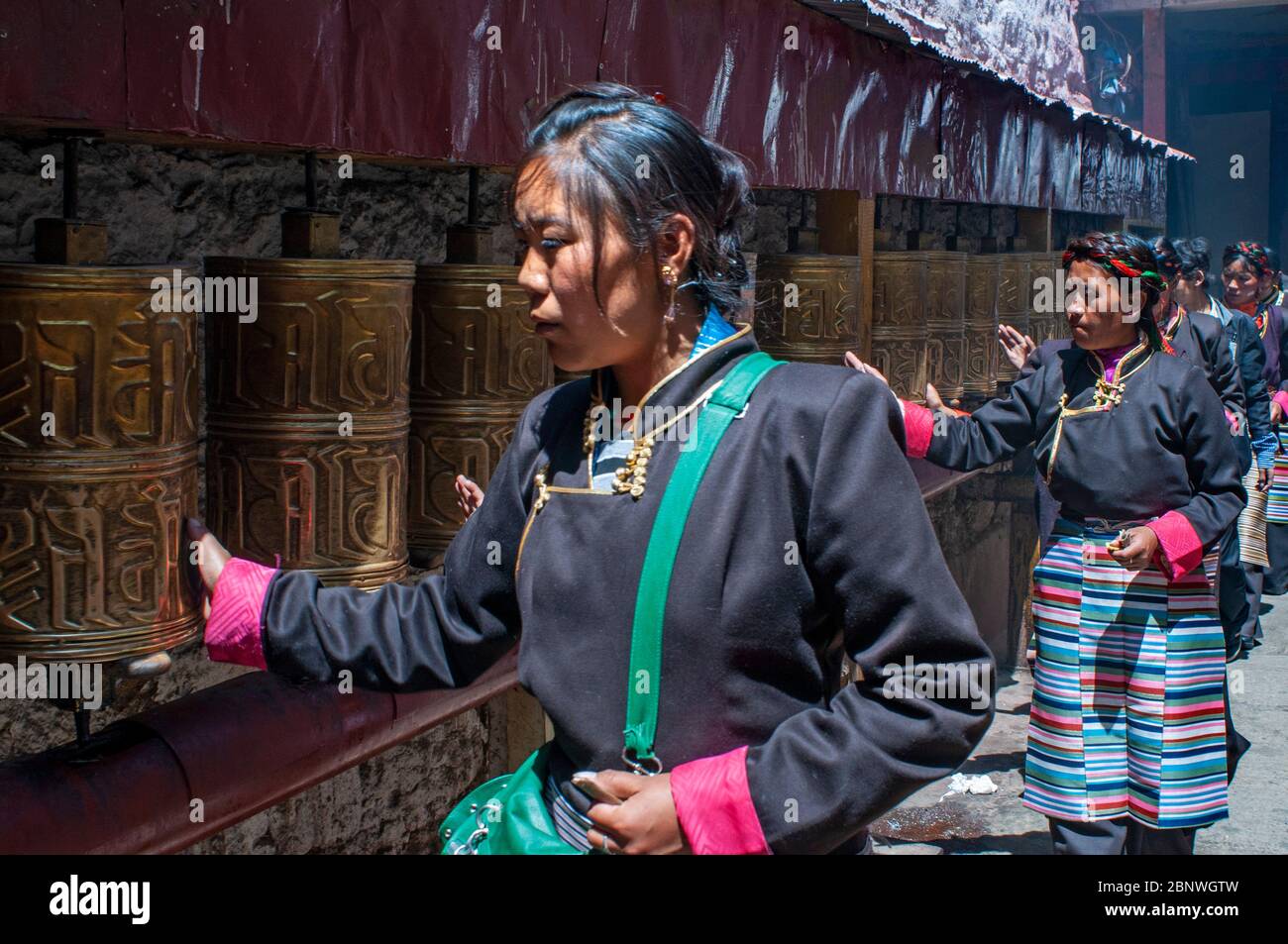 Gebetsrad im Kloster Tsepak Lhakhang. Lhasa Tibet China. Außerhalb des Ramoche-Tempels. Die Frauen machen eine Prozession um den Tempel, um den gott zu bitten Stockfoto