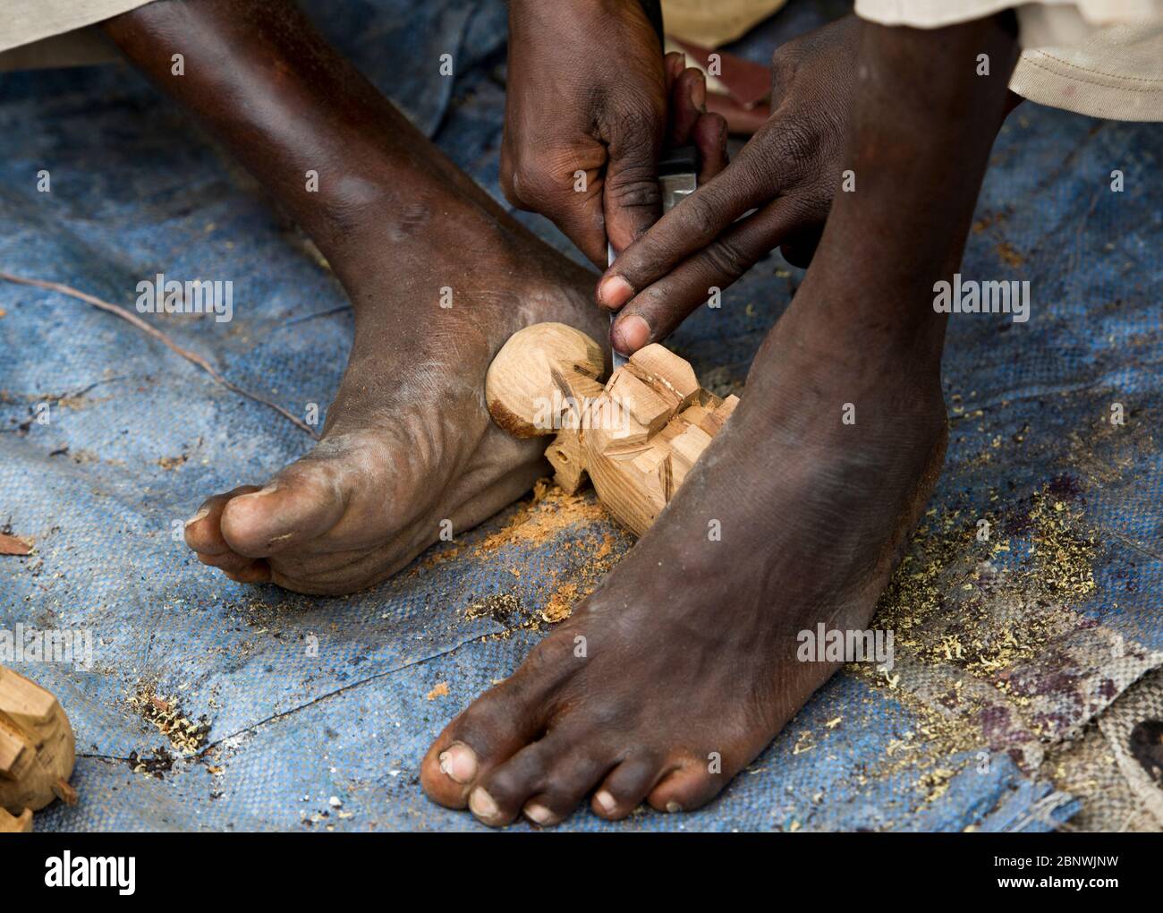 Nahaufnahme eines traditionellen Holzschnitzers Hände und Füße, Dakar, Senegal, Westafrika. Stockfoto