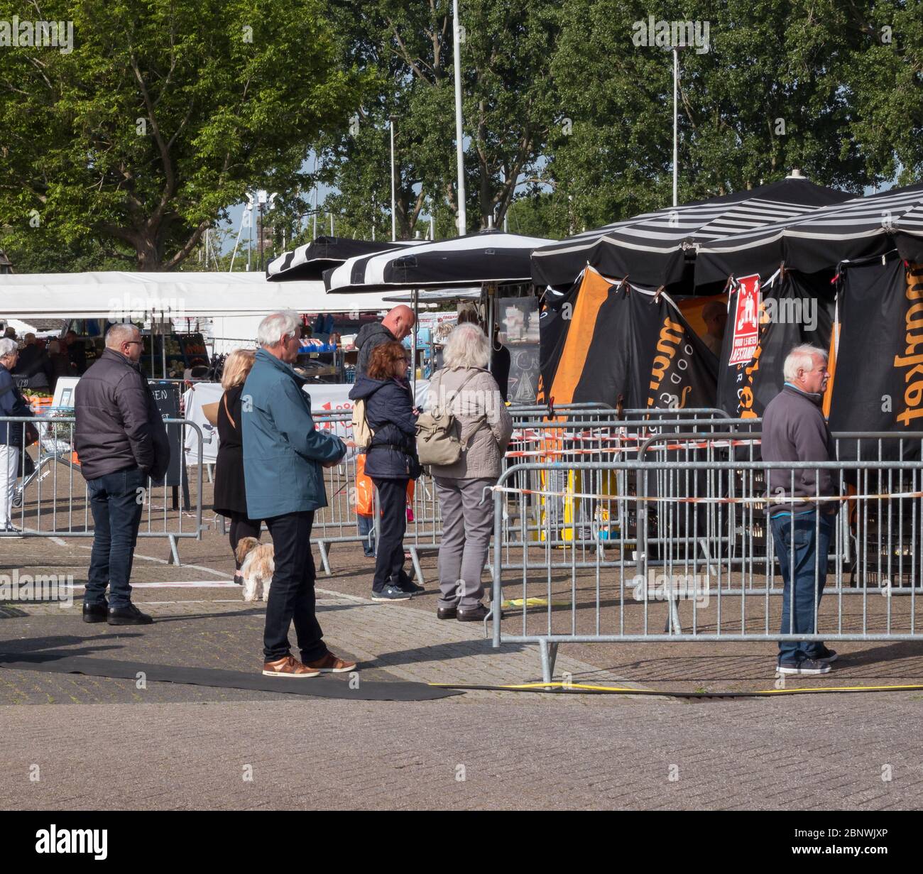Hellevoetlsuis,16-May-2020:der Markt mit den Ständen in großer Entfernung und alles auf 1.5 Meter wegen der Koronagröße Regeln, ist dies auf das Virus zurückzuführen Stockfoto