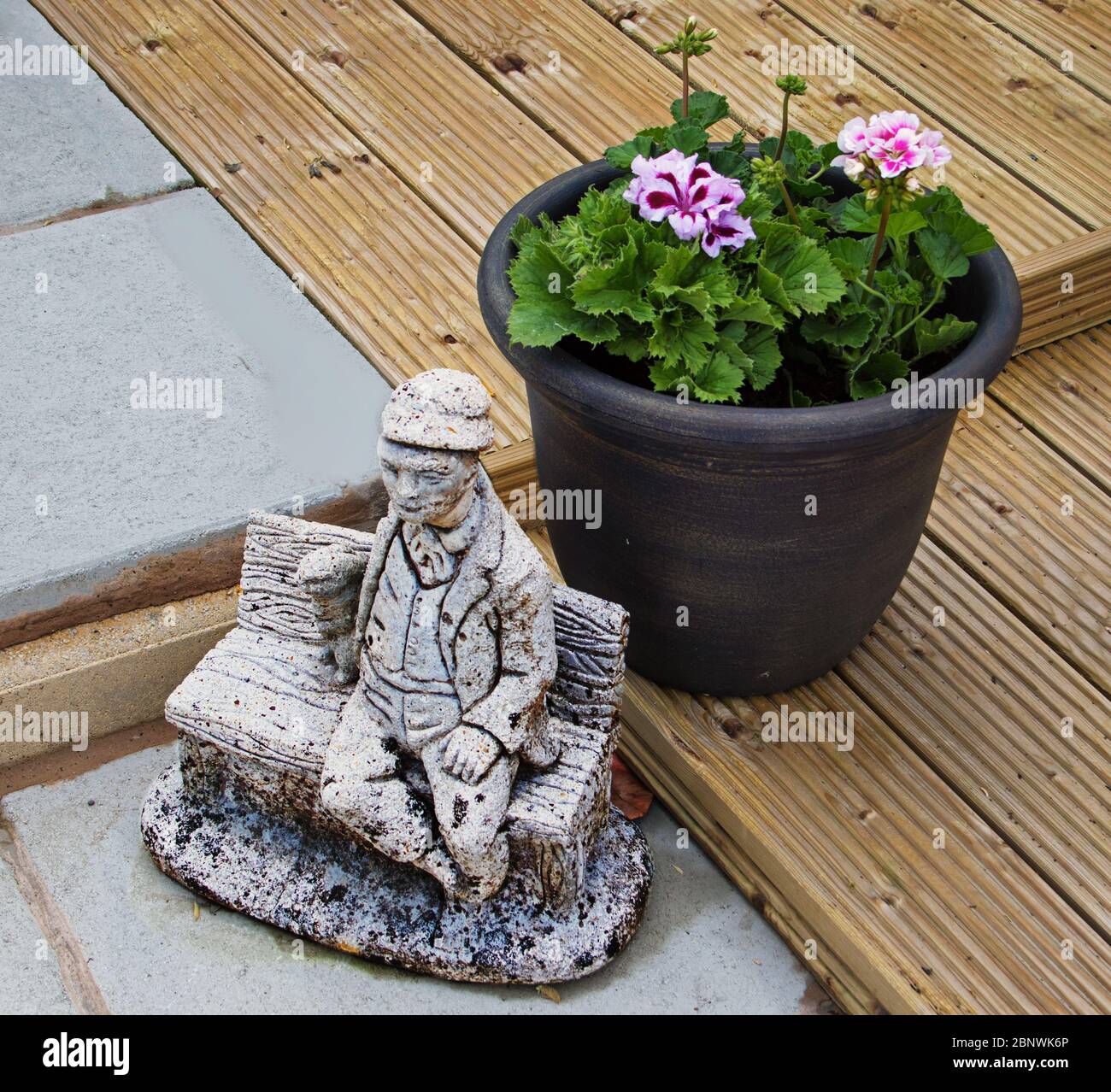 Ein Garten-Einstellung, mit einem Feature Ornament setzen einen Pflanzentopf auf Pflaster und Deck Stockfoto