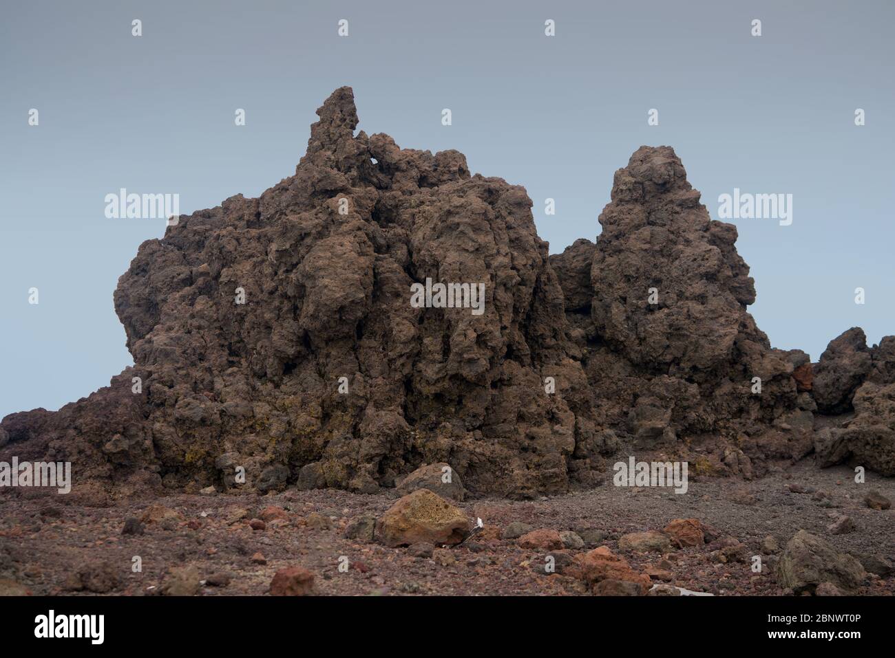 Rote vulkanische Felsen unter einem Abendhimmel Stockfoto