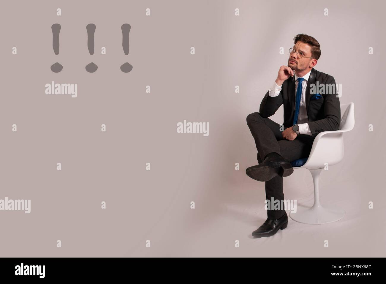 Junger Geschäftsmann sitzt auf einem Stuhl Stockfoto