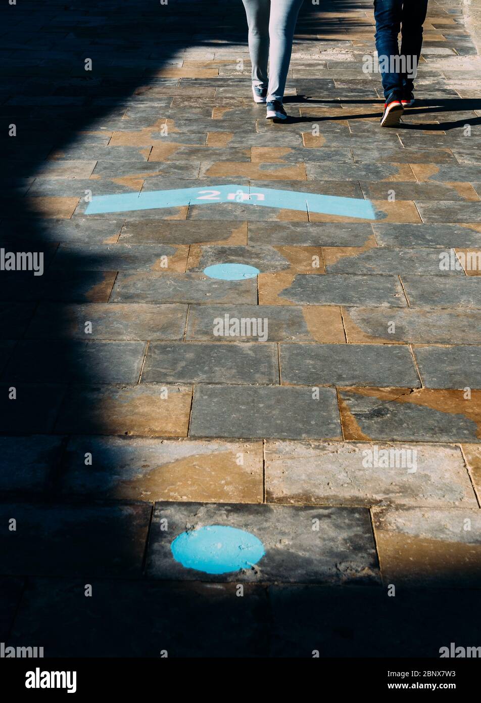 Fußabdruck-Zeichen blaue Farbe mit Text Halten Sie Ihre Entfernung mindestens zwei Meter - soziale Distanz während Coronavirus Ausbruch Stockfoto
