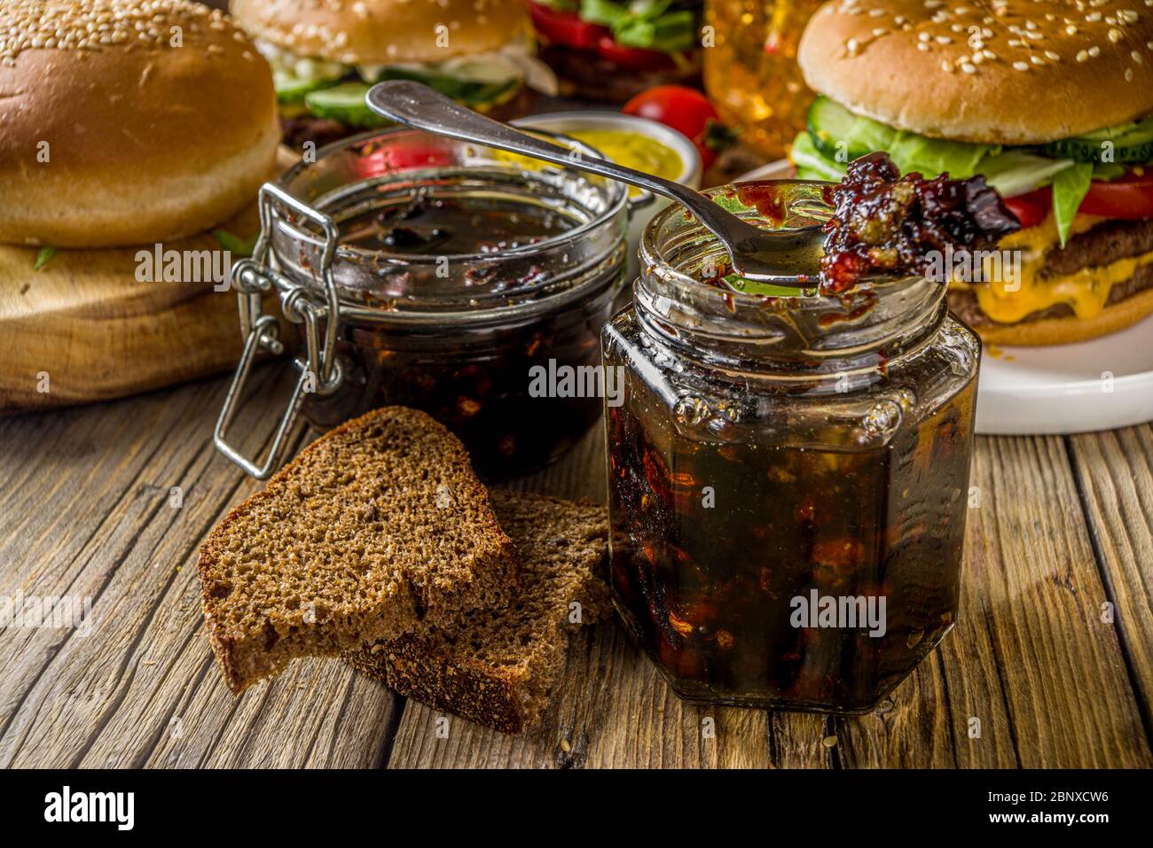 Hausgemachte Speck Marmelade in Gläsern, mit Brot und Burger Stockfoto