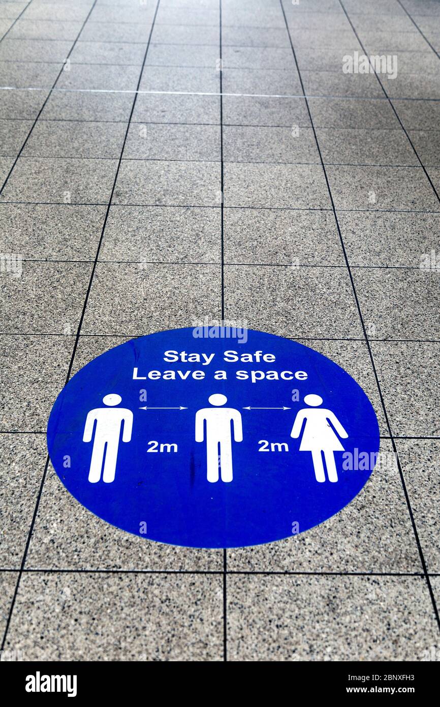16. Mai 2020 London, UK - Schilder auf dem Boden der Embankment Station erinnern Menschen daran, 2 m Abstand beim Betreten der U-Bahn während Coronavirus Pandemie Sperrung und soziale Distanzierungsmaßnahmen zu halten Stockfoto