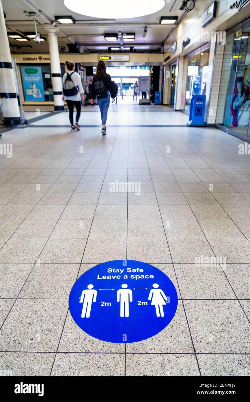 16. Mai 2020 London, UK - Schilder auf dem Boden der Embankment Station erinnern Menschen daran, 2 m Abstand beim Betreten der U-Bahn während Coronavirus Pandemie Sperrung und soziale Distanzierungsmaßnahmen zu halten Stockfoto