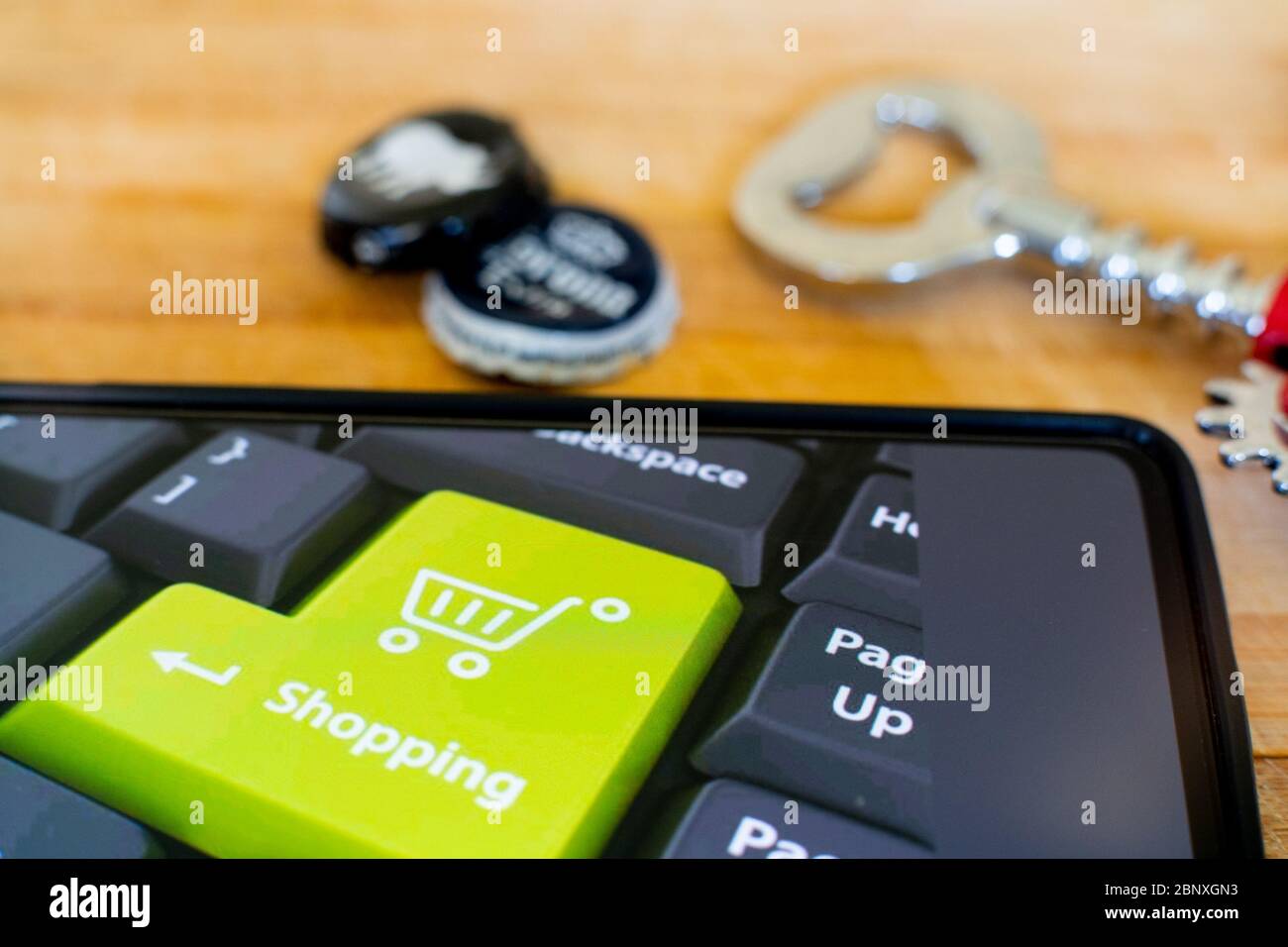 Handy zeigt Online-Shopping-Ikone mit Bierflaschen Kappen und einem Opener auf der Seite Stockfoto