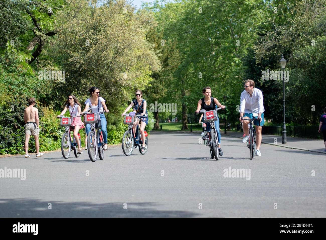 London, Großbritannien - Mai 09 2020: Eine Gruppe von Menschen in London, die während des Coronavirus mit dem Fahrrad durch den Battersea Park fahren Stockfoto